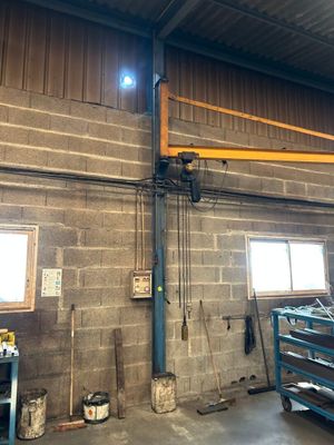 une photo d'un garage avec une grande grue suspendue au plafond