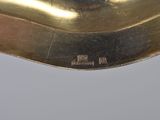 underside view of a gold plated spoon with a black handle