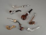 a lot of different types of smoking pipes on the table