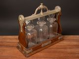 a wooden table with a glass bottle holder on it