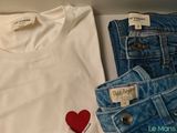 two pairs of jeans and a t - shirt sitting on a table