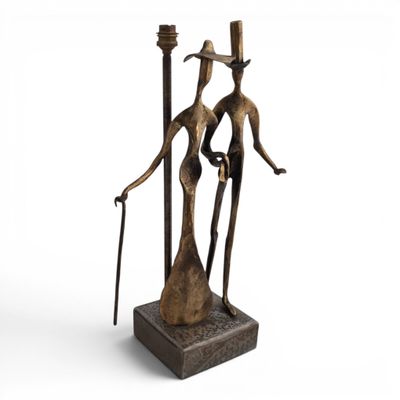 a bronze statue of a man and woman holding candles