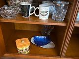 a wooden shelf with many cups and bowls on it