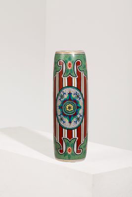 une image représentant un vase coloré posé sur une surface blanche