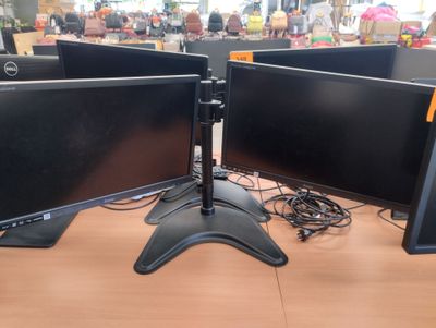 three computer monitors sitting on a desk in a store
