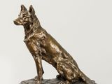 statue en bronze représentant un chien assis sur un socle en marbre