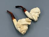 deux porte-pipes ornés de têtes sculptées, placés l'un à côté de l'autre