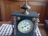 une horloge posée sur une table sur laquelle se trouve une bougie