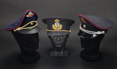 trois casquettes militaires sur une tête de mannequin, sur fond noir