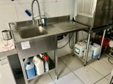 une cuisine équipée d'un évier et d'un lave-linge