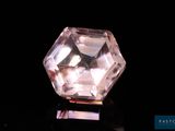 gros plan d'un diamant rose sur une surface noire