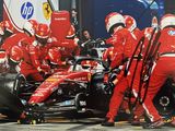 des mécaniciens Ferrari travaillant sur une voiture dans les stands