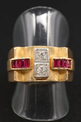 gros plan d'une bague en or avec des pierres rouges et blanches