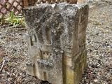 a stone block sitting in the middle of a garden