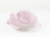 a pink rose that is sitting on a white surface