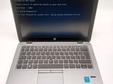 a laptop with a blue screen sitting on a white surface