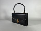 a black leather handbag with a gold handle