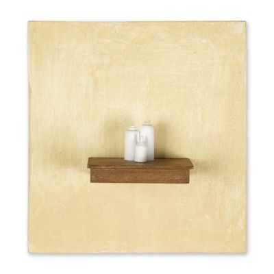 Deux bougies sont posées sur une étagère en bois adossée à un mur jaune.