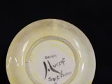 yellow and white plate with black writing on it on a black background