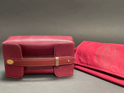 pair of red leather cases with monograms on them on a gray surface