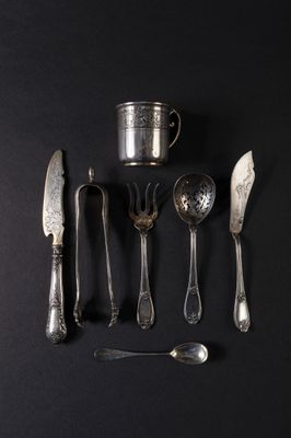a lot of silver spoons and spoons on a black surface