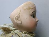 a close up of a doll with a hair on it