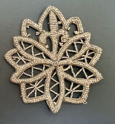 un gros plan d'un flocon de neige en perles sur une surface grise