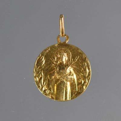 an image of a gold pendant with an image of an angel on it