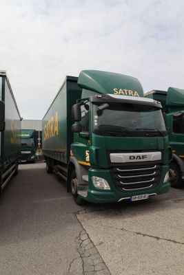 deux camions verts garés l'un à côté de l'autre sur un parking