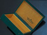 a green box that has a watch inside of it