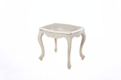 un petit tabouret blanc avec une assise en osier