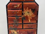 an image of a wooden chest of drawers with flowers and butterflies painted on it