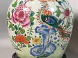 a vase with a bird on it sitting on a stand