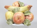 un vase blanc contenant un bouquet de fruits