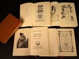 several old books are lined up on a black table