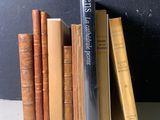 une pile de livres posée sur une table près d'un mur noir