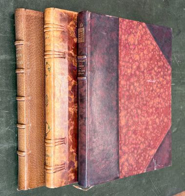 trois vieux livres posés les uns à côté des autres sur une table