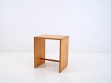 a small wooden stool sitting on a white surface