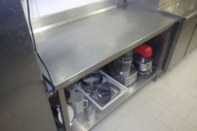 un plan de travail en acier inoxydable sur lequel sont posés des casseroles et des poêles