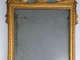 an image of a gold framed mirror hanging on a wall