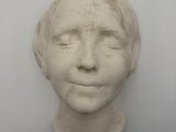 sculpture en plâtre représentant le visage d'une femme sur un mur blanc
