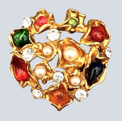 une image représentant une broche en or ornée de pierres multicolores et de perles