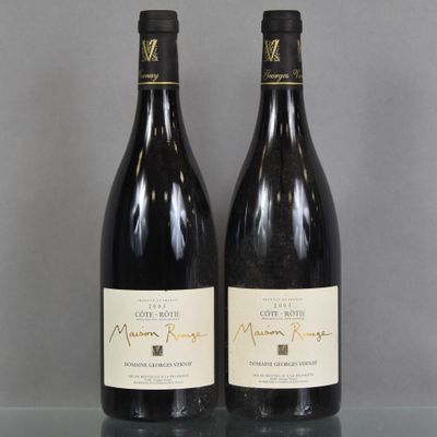 two bottles of wine are sitting on a glass table
