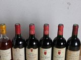 several bottles of wine are lined up on a wooden table