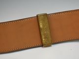 brown leather belt with a brass buckle on a white surface