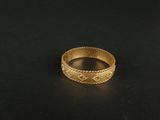 a close up of a gold ring on a black surface