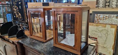 two glass cases on top of a counter in a store