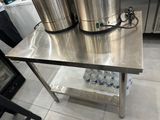 une table en acier inoxydable sur laquelle sont posés deux seaux