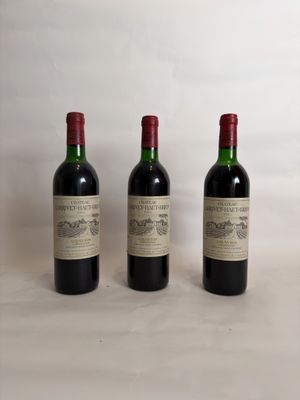 three bottles of wine are lined up on a table