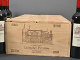 three bottles of red wine in a wooden box next to two bottles of red wine